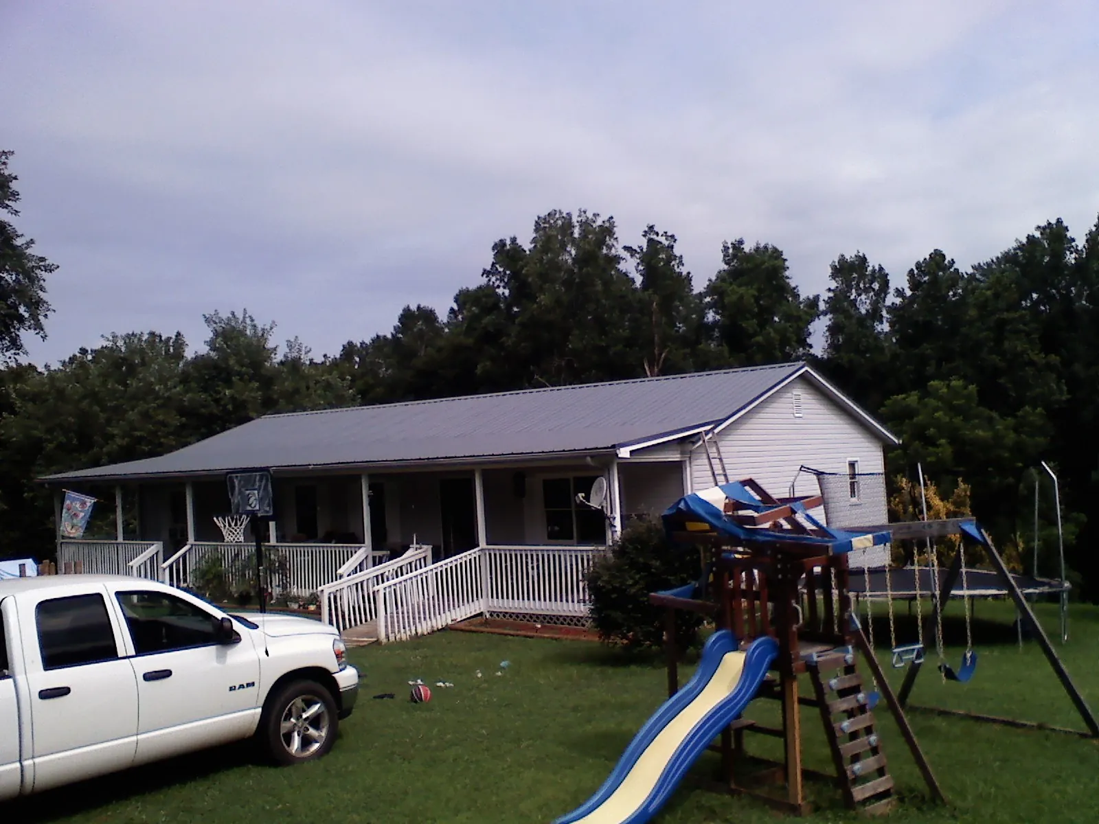 Dark metal roof on a country home with a full length front porch in Grover