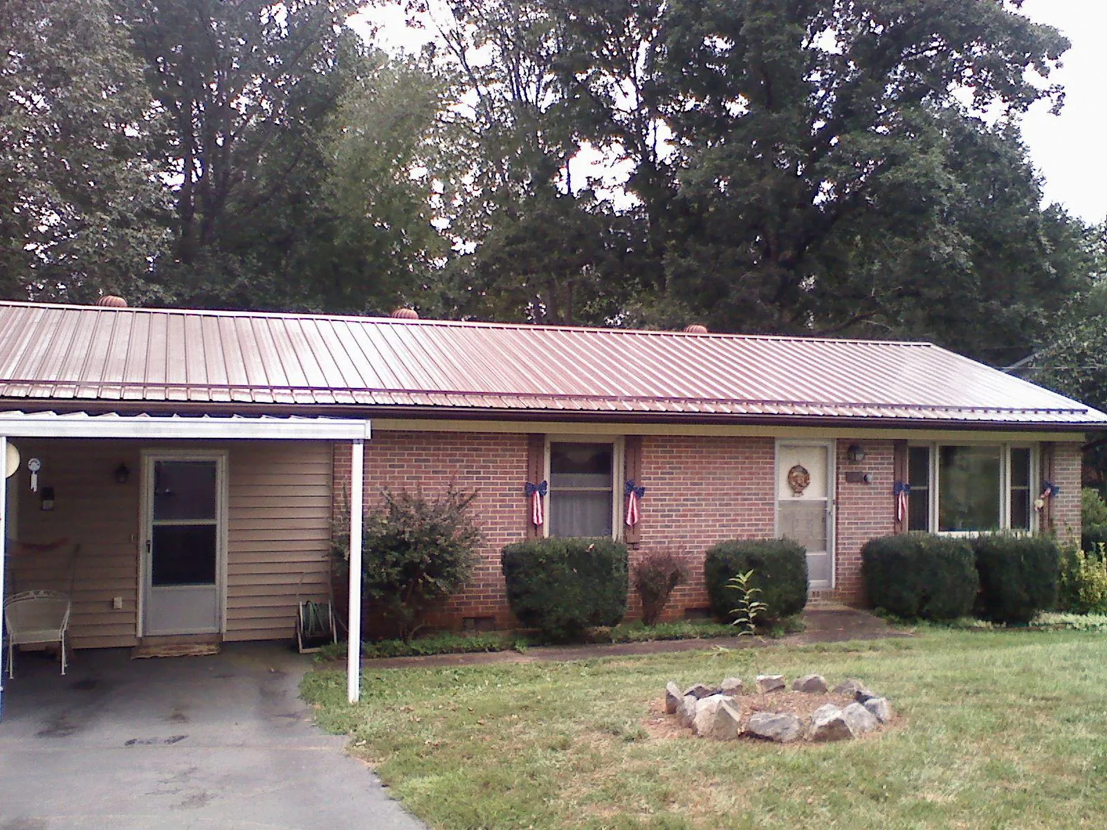 Bronze metal roof and carport on a brick ranch home — Roof Repair work by our crew in Grover